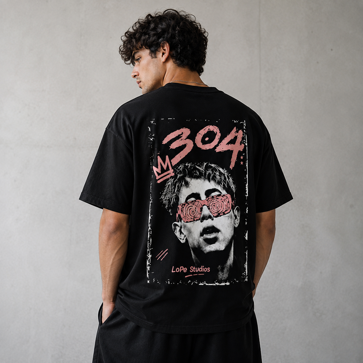 Modelo de espaldas con camiseta negra 304 BLACK de LoPe Studios y gráfica rosa y blanca